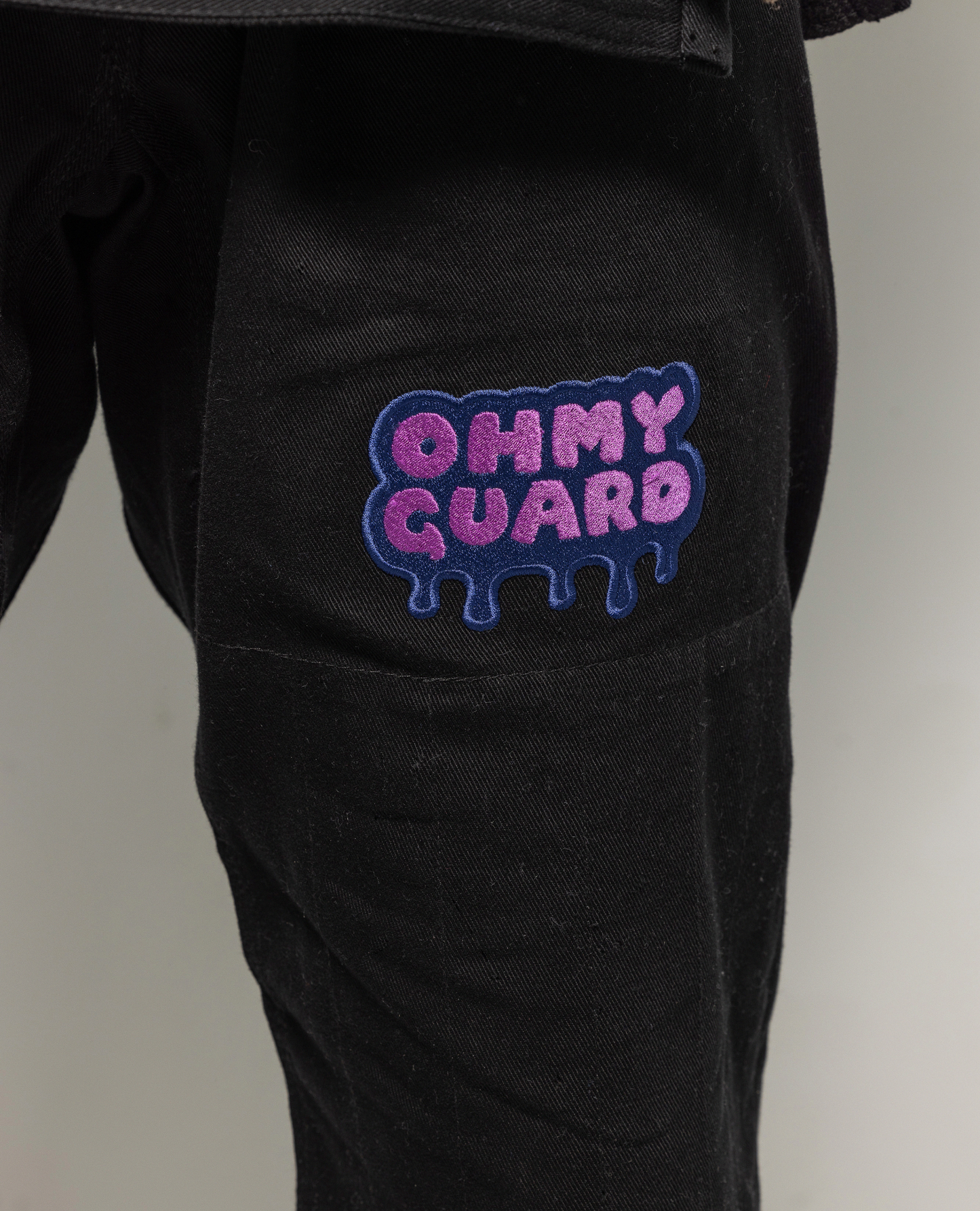 Close up of OhmyGuard logo on black gi pant leg