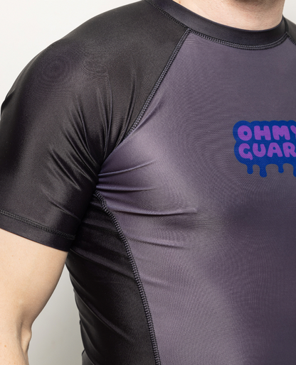 Close up of a man in a black and grey shortsleeve rashguard